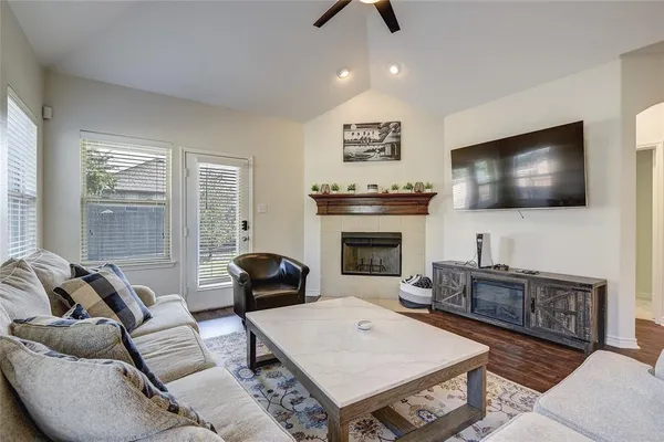 a living room with furniture a flat screen tv and a fireplace
