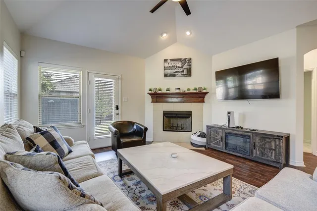 a living room with furniture a flat screen tv and a fireplace