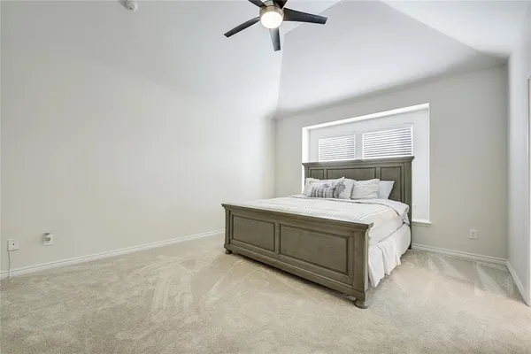 a room with a bed and ceiling fan