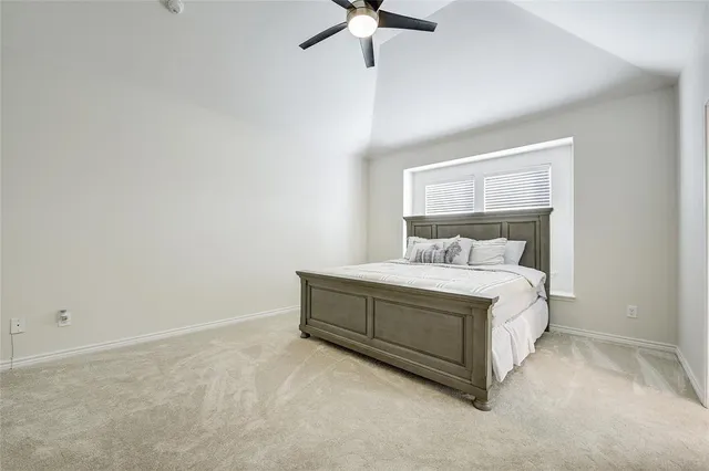 a room with a bed and ceiling fan