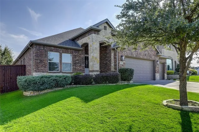 a front view of a house with a yard and trees