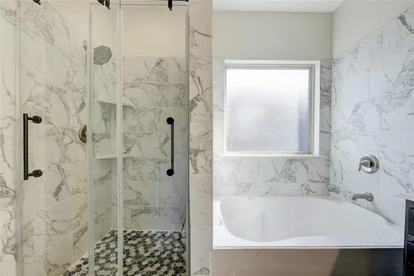 a bathroom with a bathtub and shower