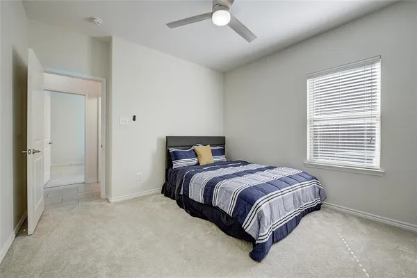 a bed sitting in a bedroom next to a window and a chandelier