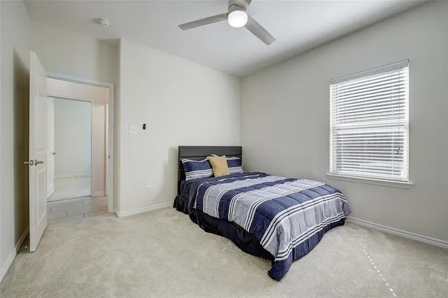 a bed sitting in a bedroom next to a window and a chandelier