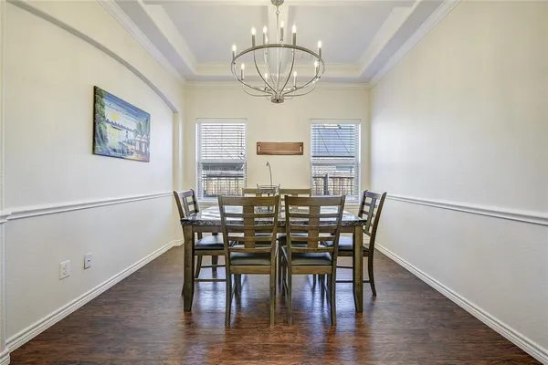 a view of a dining room with furniture a chandelier and wooden floor