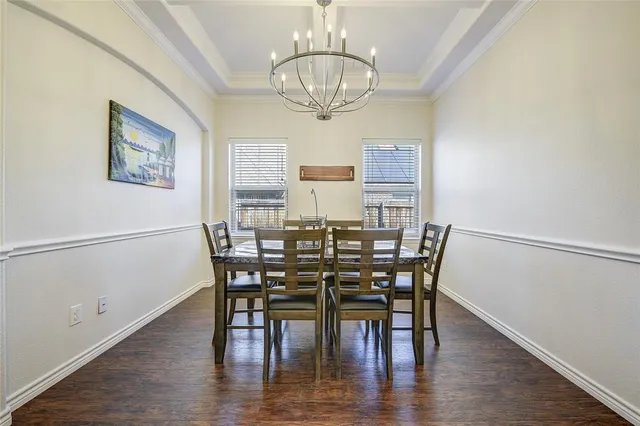 a view of a dining room with furniture a chandelier and wooden floor