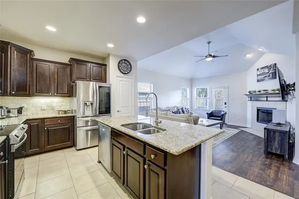 a kitchen with stainless steel appliances granite countertop a sink stove and refrigerator