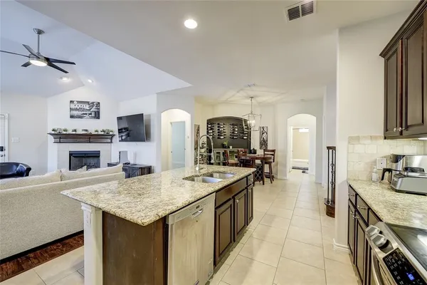 a kitchen with sink stove and refrigerator