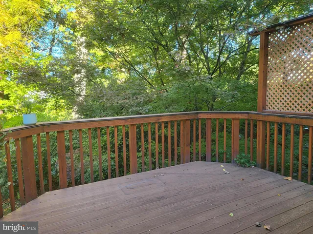 a balcony with wooden floor and trees