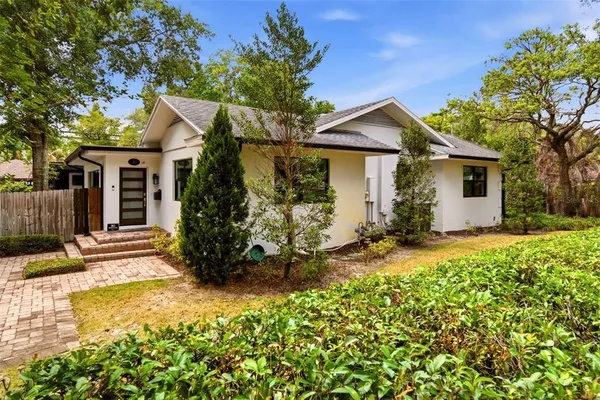 a view of a house with a small yard and potted plants