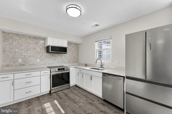 a kitchen with a sink stainless steel appliances and cabinets