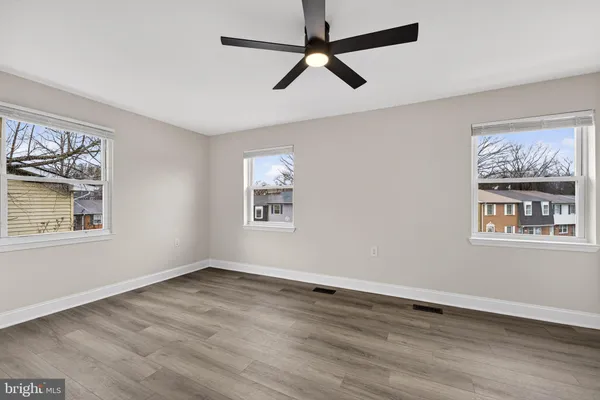a view of empty room with wooden floor and window
