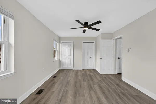 a view of empty room with wooden floor and window