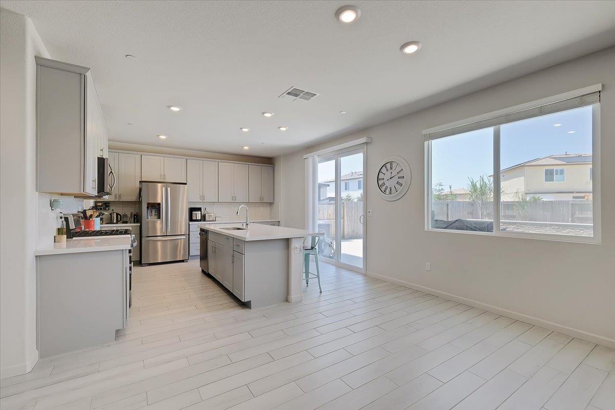 794 Berryessa Way Olivehurst, CA 95961 - Photo 12 of 40 a kitchen with stainless steel appliances granite countertop a refrigerator a sink dishwasher a stove and white countertops with wooden floor