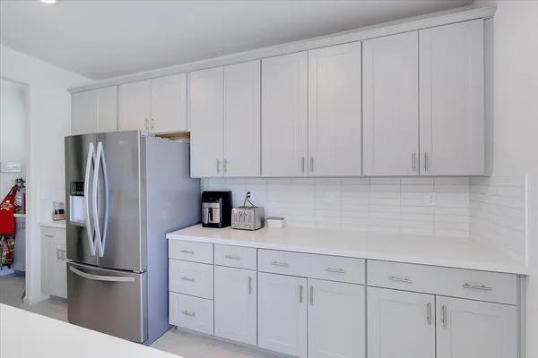 a kitchen with stainless steel appliances white cabinets and a refrigerator