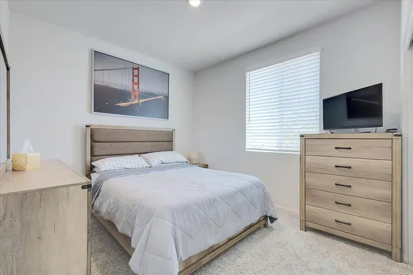 a bedroom with a bed and a flat screen tv
