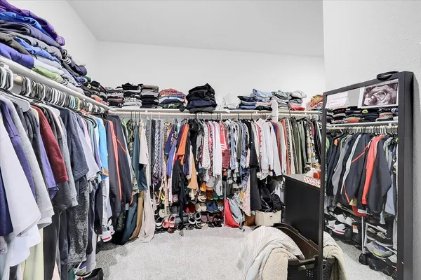 a view of walk in closet with clothes