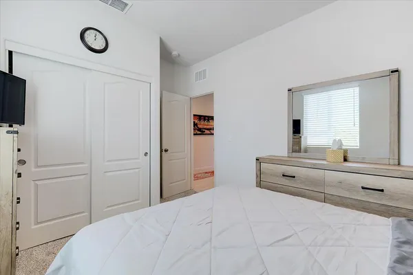 a spacious bedroom with a bed and a flat screen tv