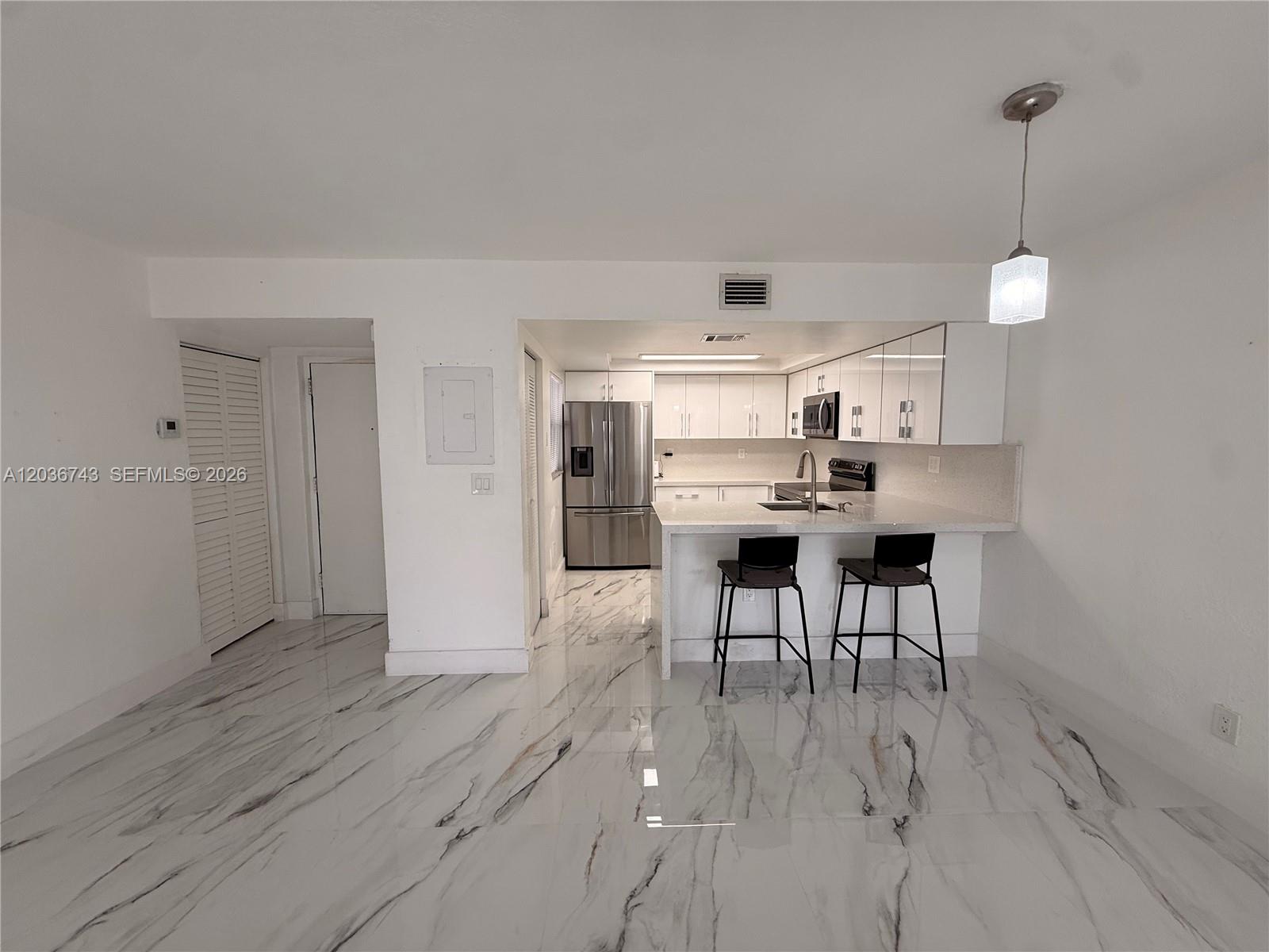 10875 Northwest 7th Street, Unit 1136 Miami, FL 33172 - Photo 9 of 25 a view of a kitchen with dining table and chairs