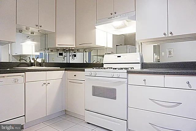 a white stove top oven sitting inside of a kitchen