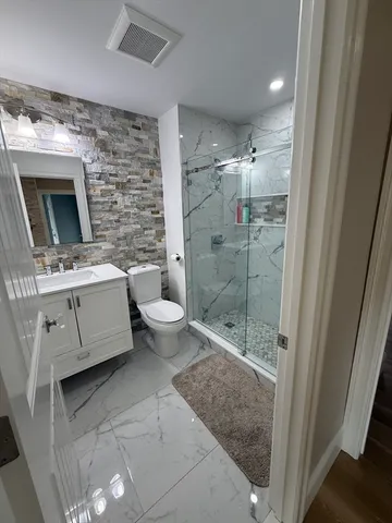 a bathroom with a toilet a sink and glass door