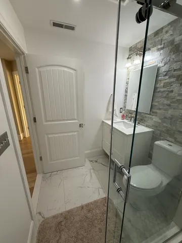 a bathroom with a toilet and a shower