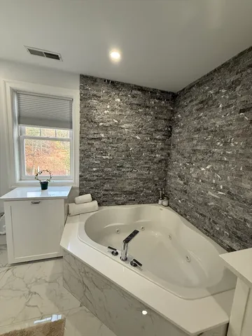 a bath tub sitting in a bathroom next to a window