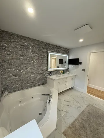 a bathroom with a sink a mirror and a bathtub