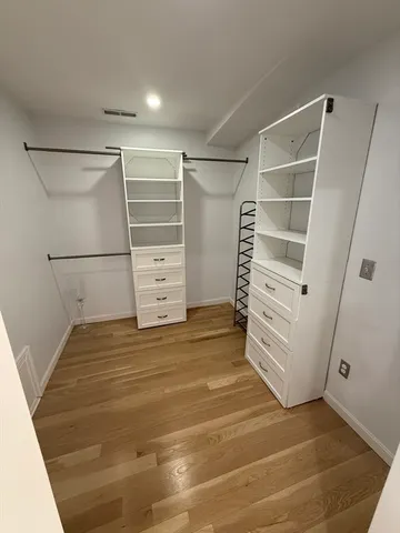 a view of walk in closet with empty racks