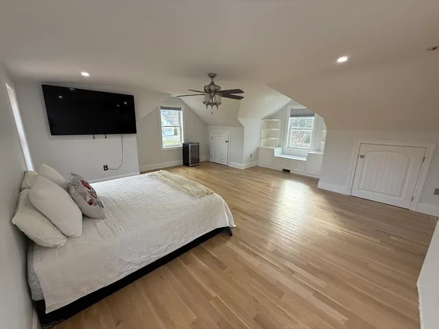 a spacious bedroom with a bed and a flat screen tv