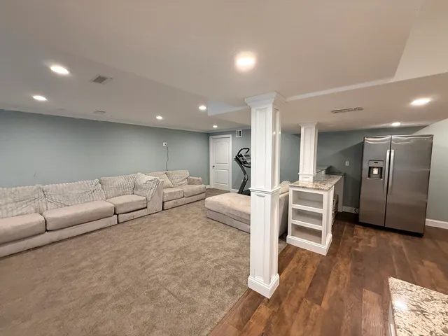 a living room with furniture and a wooden floor