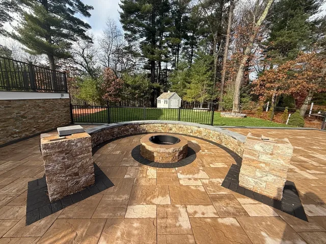 a backyard of a house with table and chairs and a barbeque with potted plants