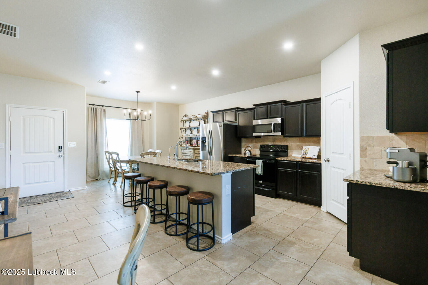 7348 100th Street Lubbock, TX 79424 - Photo 13 of 55 a kitchen with stainless steel appliances kitchen island granite countertop a sink counter space and cabinets