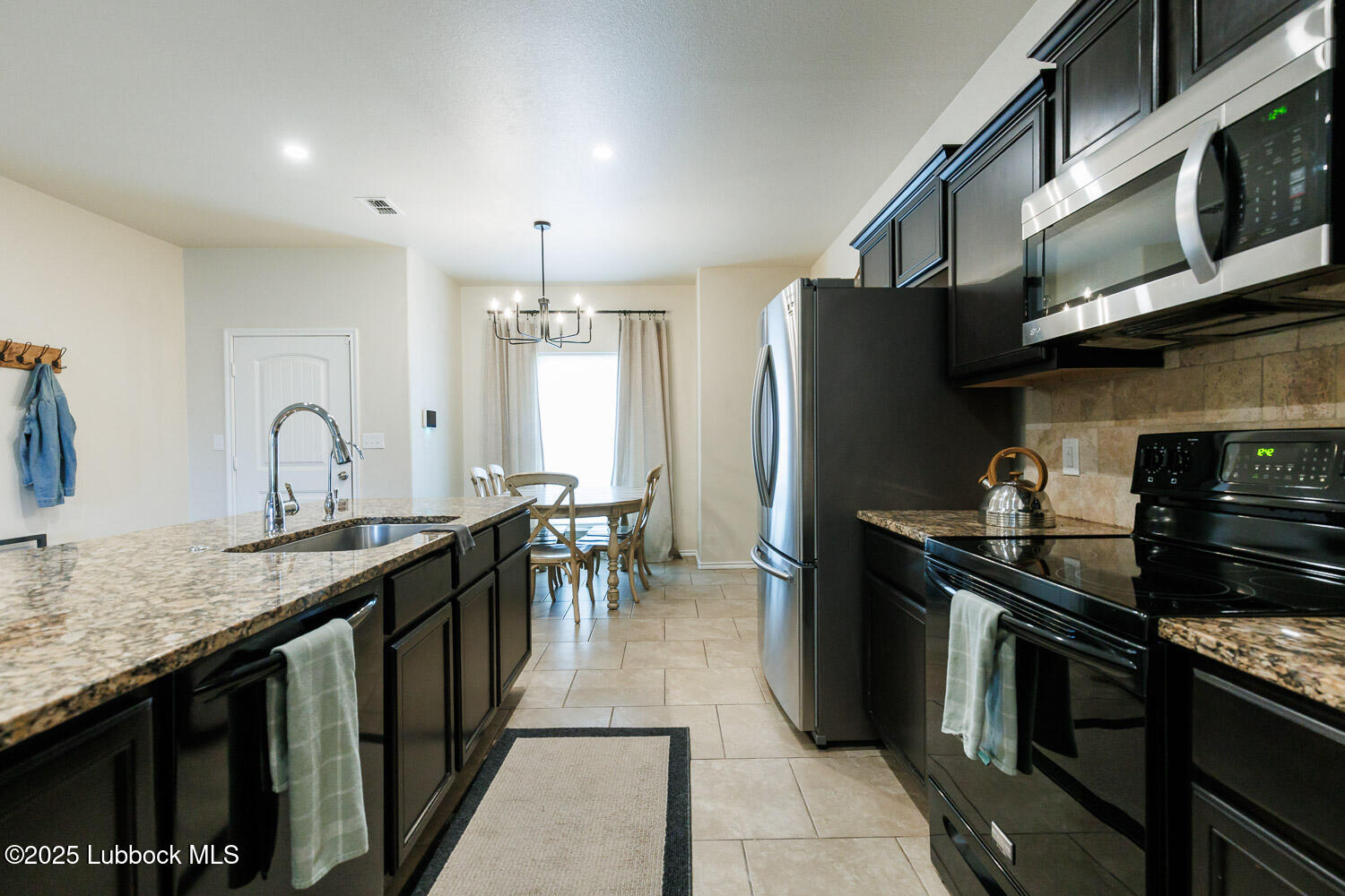 7348 100th Street Lubbock, TX 79424 - Photo 16 of 55 a kitchen with stainless steel appliances granite countertop a sink stove and refrigerator