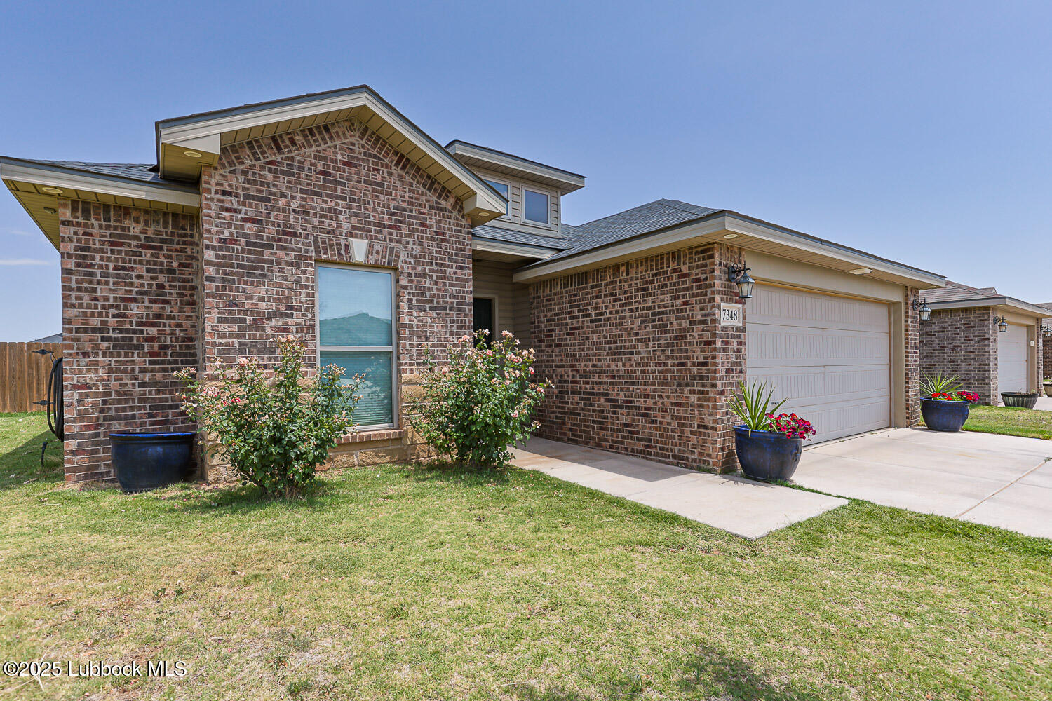 7348 100th Street Lubbock, TX 79424 - Photo 2 of 55 a front view of a house with garden