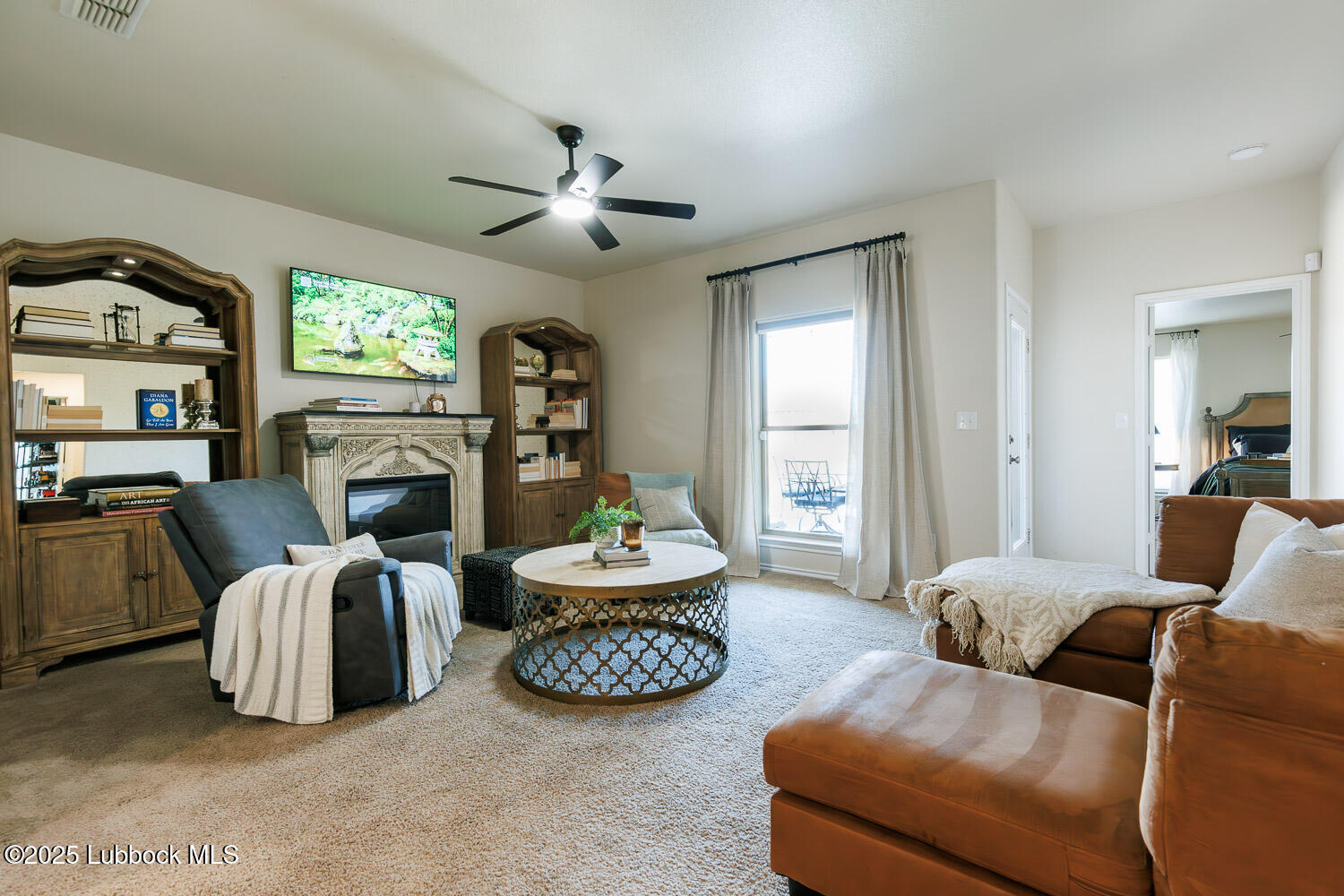 7348 100th Street Lubbock, TX 79424 - Photo 23 of 55 a living room with furniture a fireplace and a large mirror
