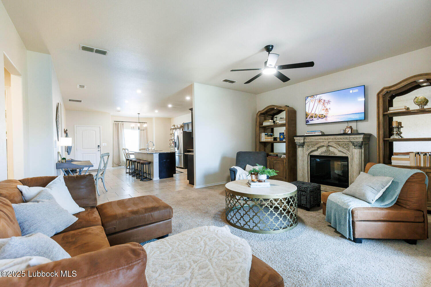 7348 100th Street Lubbock, TX 79424 - Photo 25 of 55 a living room with furniture a fireplace and a chandelier