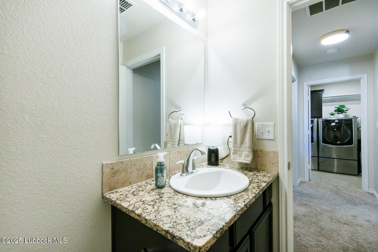 7348 100th Street Lubbock, TX 79424 - Photo 39 of 55 a bathroom with a granite countertop sink and a mirror