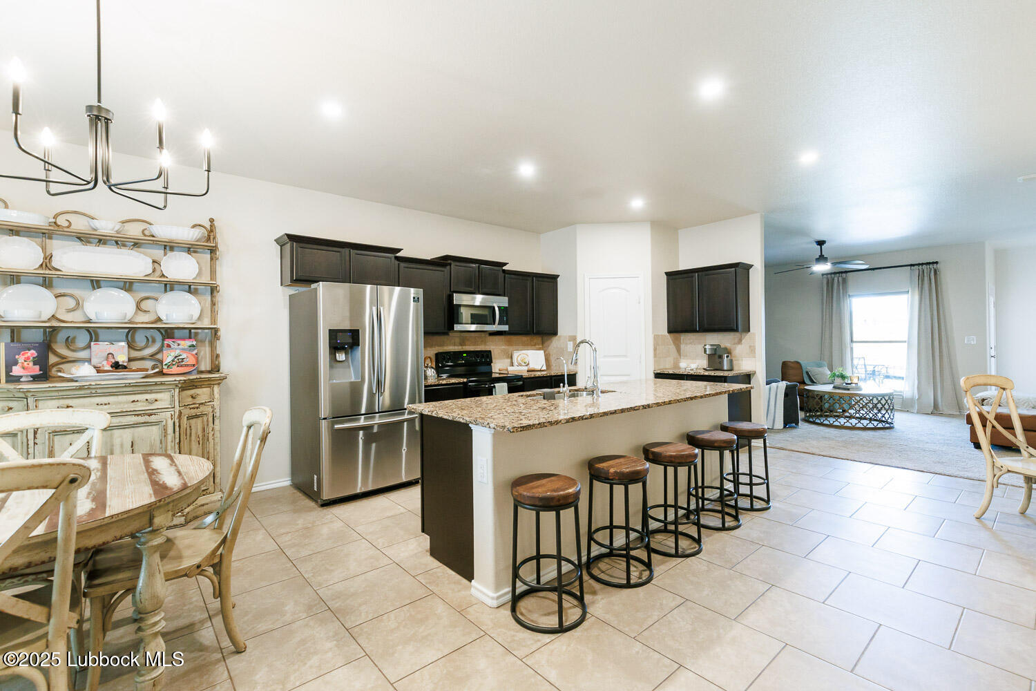 7348 100th Street Lubbock, TX 79424 - Photo 7 of 55 a kitchen with stainless steel appliances a table chairs refrigerator and microwave