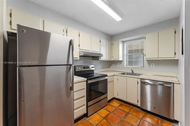 a kitchen with stainless steel appliances granite countertop a refrigerator sink and stove