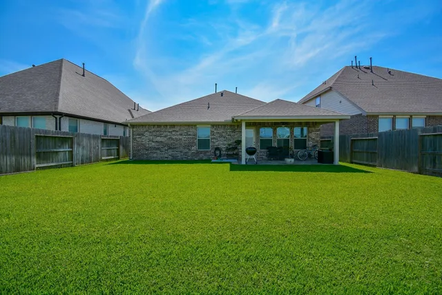 a view of a chair and table in backyard of house