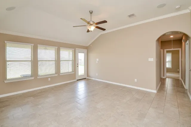 a living room with furniture a flat screen tv and a large window