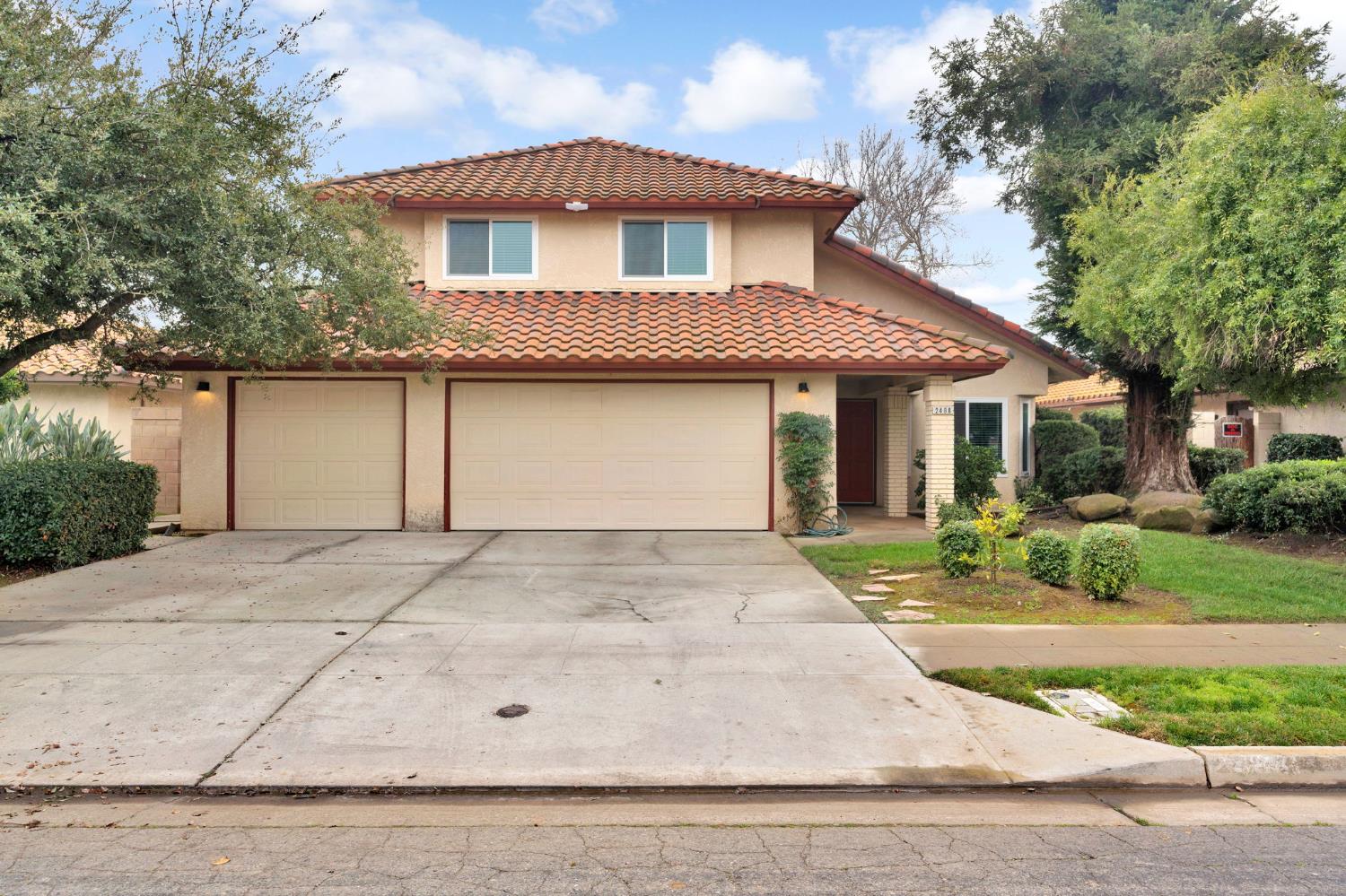 mediterranean / spanish house featuring a garage, stucco siding, concrete driveway, and a tile roof