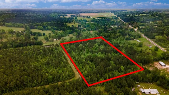 an aerial view of a houses with a lush green hillside