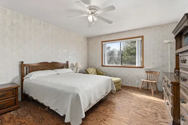 a bedroom with bed and wooden floor