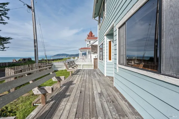 a balcony with wooden floor table and chairs