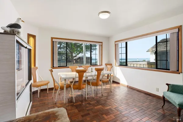 a view of a dining room with furniture large windows and wooden floor
