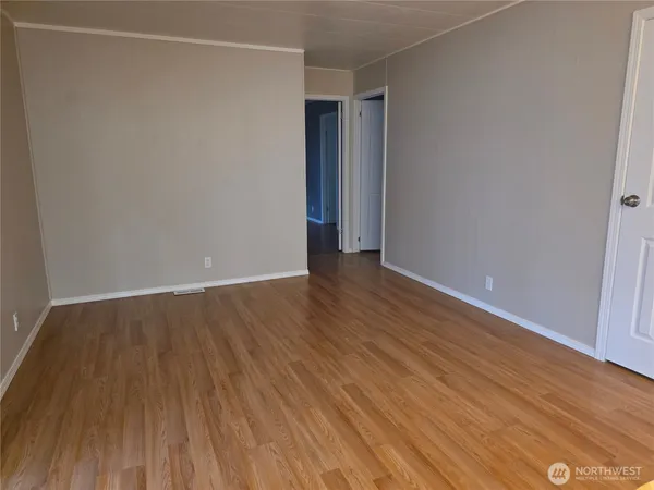 a view of an empty room with wooden floor