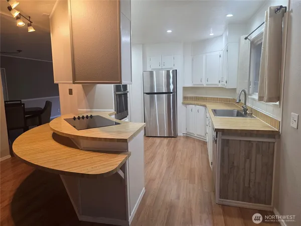 a kitchen with stainless steel appliances granite countertop a sink refrigerator and microwave