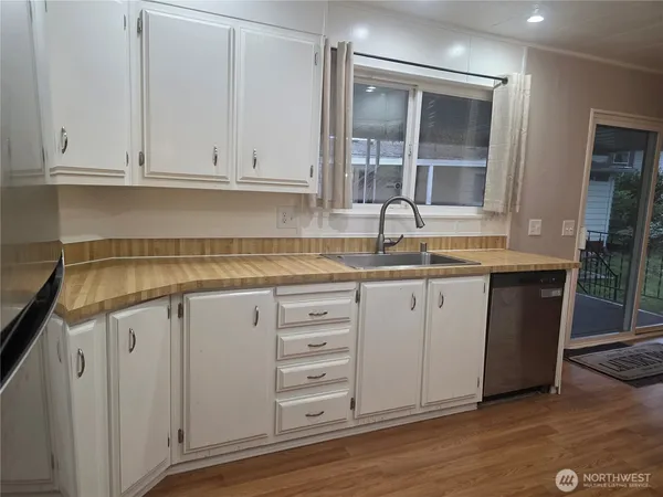 a kitchen with granite countertop white cabinets and sink